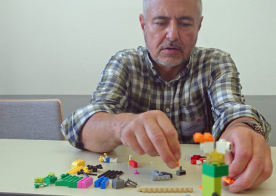 Helmut Müller, ehrenamtlicher Beisitzer im SKM Bundesvorstand, beim Um-die-Ecke-Denken mit Legosteinen